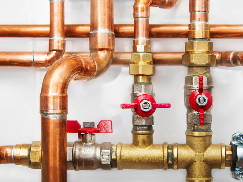 A close up of pipes and valves on the wall